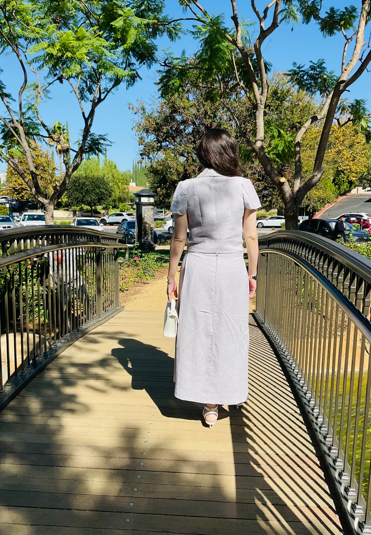 Back view of The Silent Dove 2-piece gray linen suit showing the tailored fit and maxi skirt back zipper